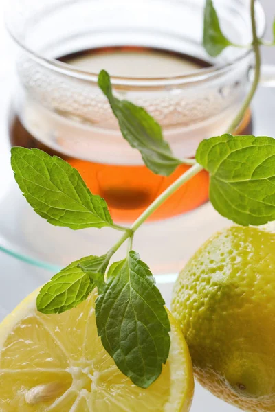 Tee im Glas mit Zitrone und frischen Minzblättern - Kräutertee — Stockfoto