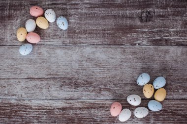 Ahşap arka planda pastel renkli paskalya yumurtaları. Paskalya kartı için boş. Metnin için yer.
