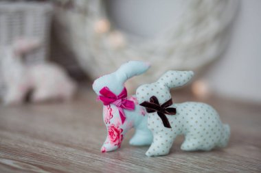 El yapımı paskalya tavşanları, beyaz ahşap arka planda, hafif bir iç mekanda.