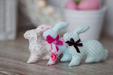 El yapımı paskalya tavşanları, beyaz ahşap arka planda, hafif bir iç mekanda.