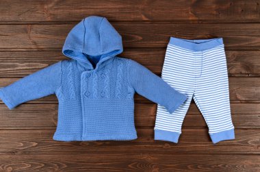 Mavi bebek örgü hırka ve ahşap backgro çizgili pantolon