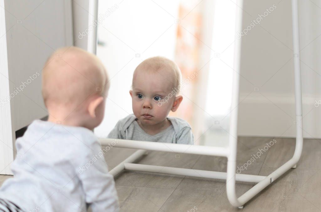 Fun cute baby seeing self in mirror