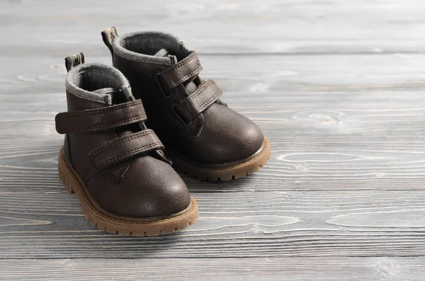 Scarpe per bambini in pelle marrone su sfondo di legno — Foto Stock