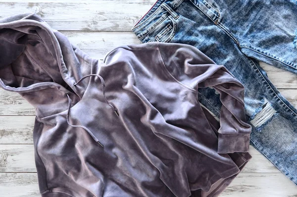 Roupas femininas (capuz de veludo violeta, jeans lavados com ácido) em woo — Fotografia de Stock