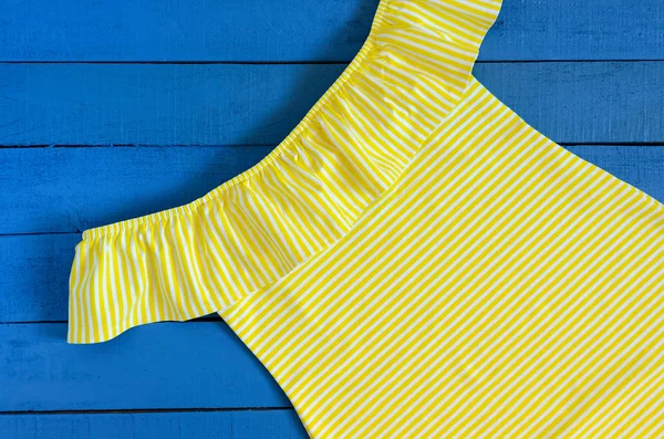 Vestido amarillo sobre fondo de madera azul. Ropa de mujer. Rayas — Foto de Stock