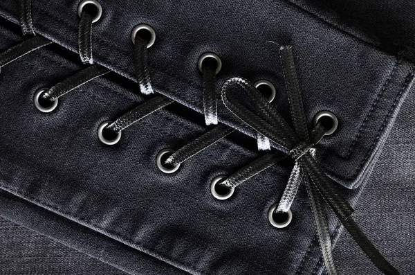 Washed black denim, lace-up details. Jeans background, texture