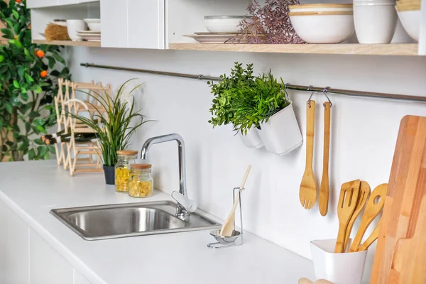 Fechar o interior da moderna cozinha branca com utensílios de cozinha de madeira e tangerina no fundo — Fotografia de Stock