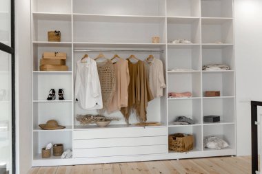 Minimalist İskandinav beyaz ahşabının sebze dolabında nötr bej renklerde gardıropla yürümesi