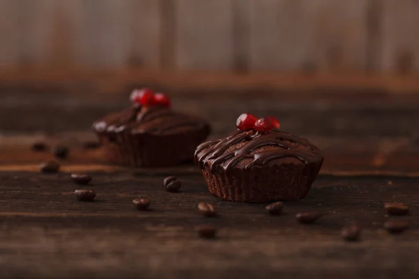 Sweet chocolate muffins with pomegranate in a rustic style with coffee grains — Stock Photo, Image