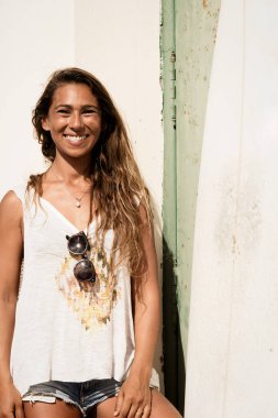 Kız ayağa grunge kapısının önünde bir surfboard ile.