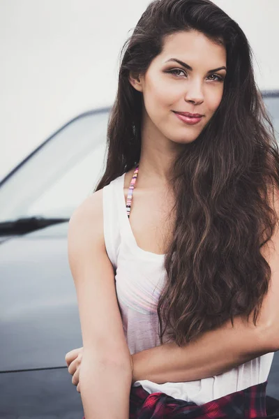 Portrait of a smiling young woman with car in background. — Stock Photo, Image