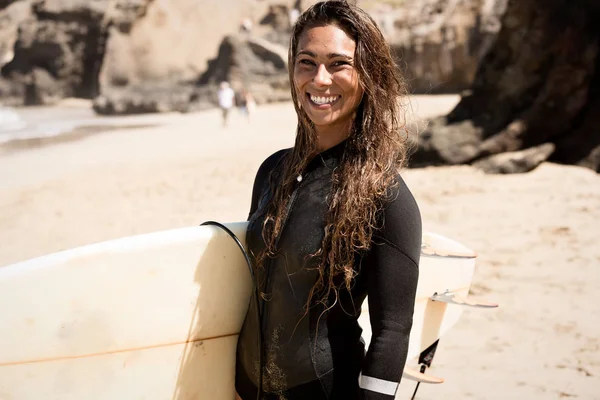 Mädchen steht mit Surfbrett am Strand — Stockfoto