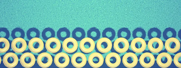 Yüzme havuzunda izole renkli yüzmek yüzüğü. 3D render — Stok fotoğraf