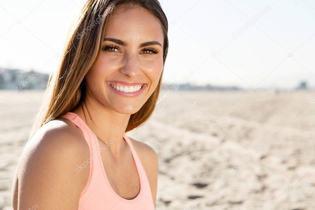 beautiful young woman smiling at the beach.