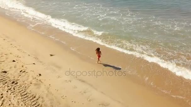Feliz joven mujer saltando y corriendo en la playa . — Vídeos de Stock