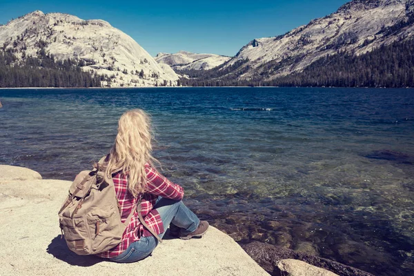 Mujer sentada en un lago en el Parque Yosemite. concepto wanderlust —  Fotos de Stock