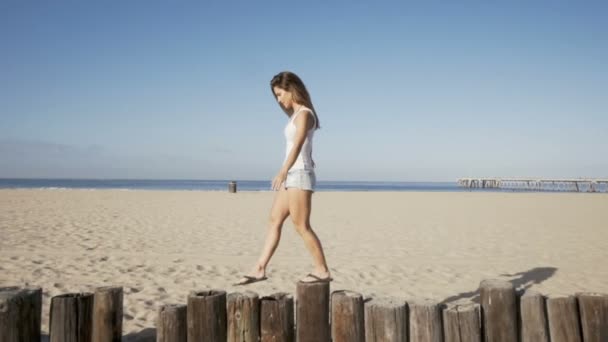 Happy young woman balance at wood bollards. summer feeling — Stock Video