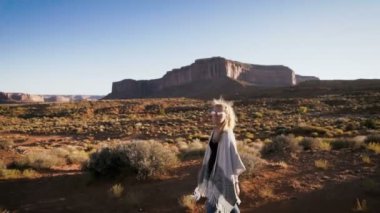 Monument Valley içinde kırmızı kayalar genel bakış ile yürüyen kadın.