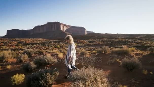 Kvinnan promenader i Monument Valley med röda klippor översikt. — Stockvideo