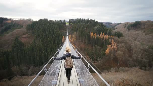 Mulher andando sobre ponte de corda pendurada na alemanha. conceito de wanderlust — Vídeo de Stock