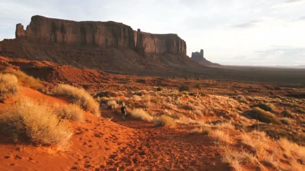 Monument Valley içinde kırmızı kayalar genel bakış ile yürüyen kadın. — Stok video