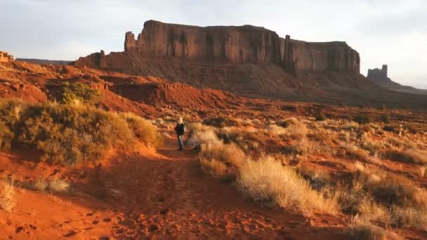 Жінка вигулює в Monument Valley зйомки фотографій з смартфон. — стокове відео