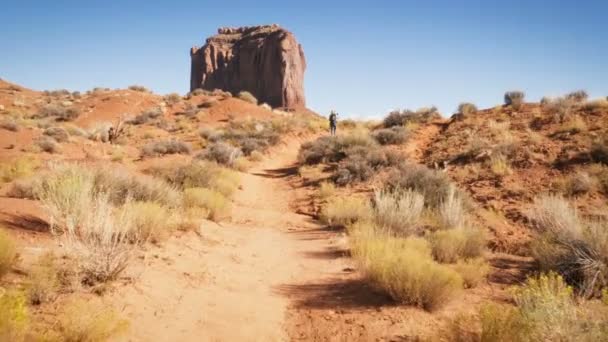 Жінка вигулює в Monument Valley, з червоних скель огляд. — стокове відео