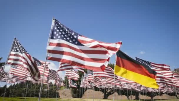 Zeitlupe schwenkt deutsche Flagge zwischen amerikanischen Flaggen. Diplomatisches Konzept — Stockvideo