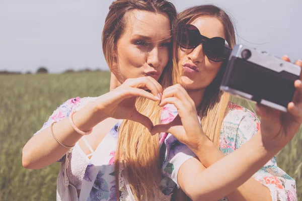 Hermanas gemelas haciendo una selfie con cámara retro — Foto de Stock