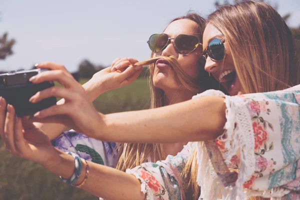 Hermanas gemelas haciendo una selfie con cámara retro — Foto de Stock