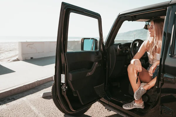Το κορίτσι του σέρφερ που κάθεται στο αυτοκίνητο στην παραλία. τρόπος ζωής στην Καλιφόρνια — Φωτογραφία Αρχείου