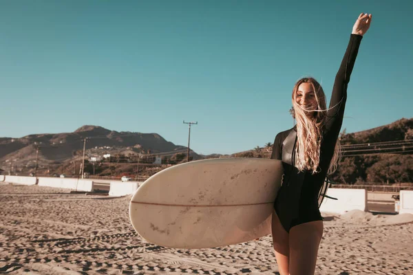 Giovane donna in piedi con tavola da surf sulla spiaggia di Malibu. stile di vita california — Foto Stock