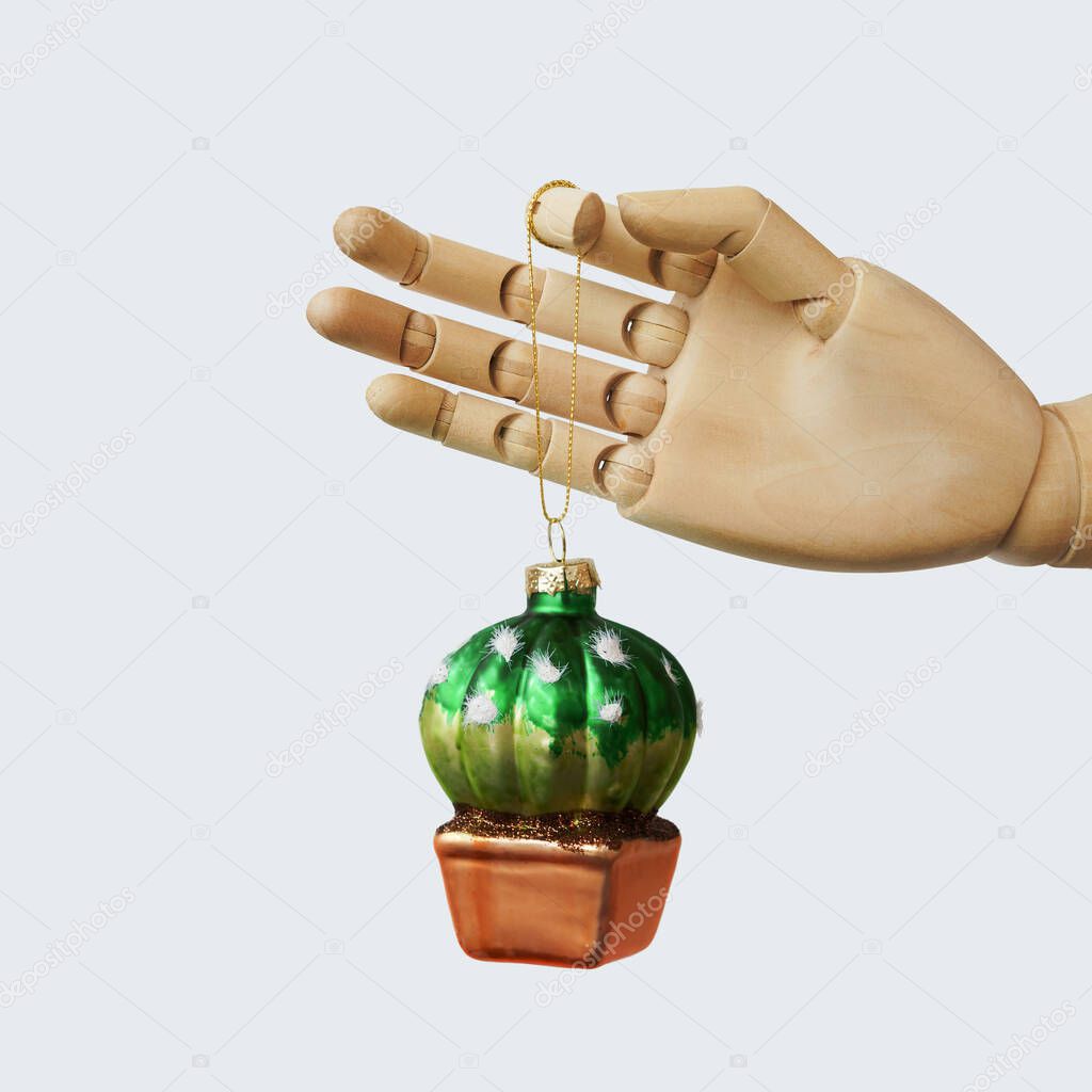 Glass Christmas toy in the shape of a cactus holding by mock up of a hand