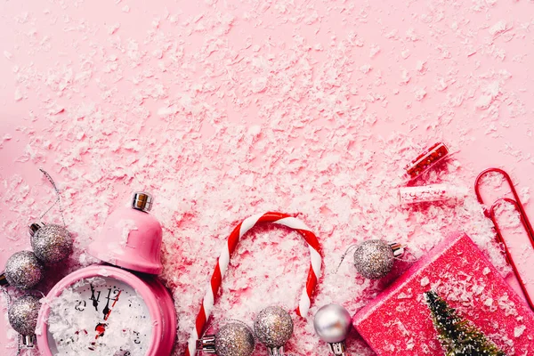 Çalar saat, gümüş Noel topları, çizgili baston, hediye paketi.