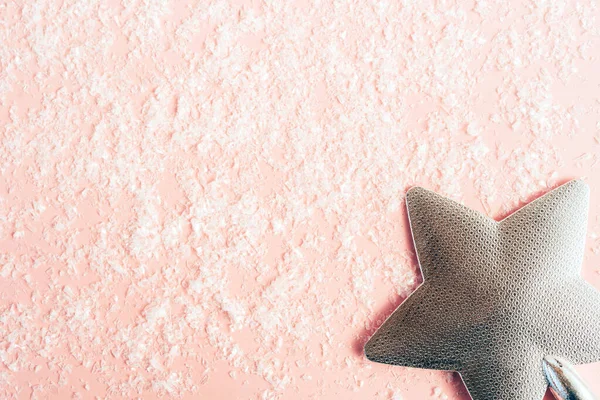 Pastel pembe kar arkaplanındaki şenlik ağacı için gümüş noel yıldızı