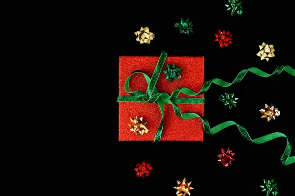 Arcos dorados, verdes y rojos alrededor de la caja para envoltura de regalo — Foto de Stock
