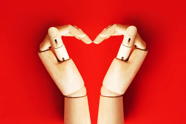 Két fa kéz hajtogatott alakú szív piros háttér — Stock Fotó