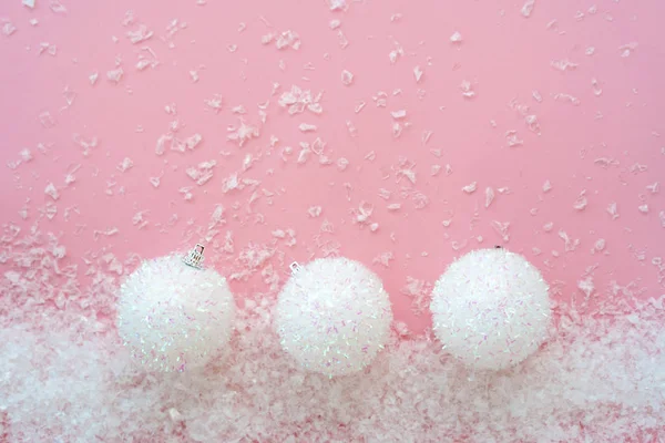 粉色人造雪原背景下的三颗圆形圣诞球 — 图库照片