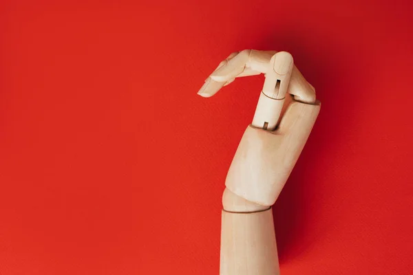 Una mano de madera doblada en forma de medio corazón sobre fondo rojo — Foto de Stock