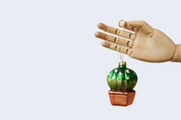 Boule de Noël en verre en forme de cactus tenant une main factice — Photo