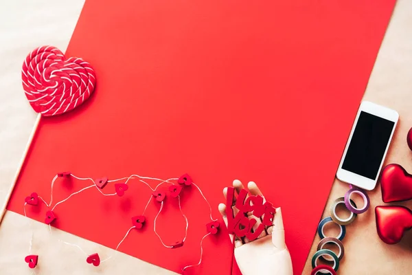 Szív alakú nagy piros-fehér csíkos cukor nyalóka, fa kézi telefon — Stock Fotó