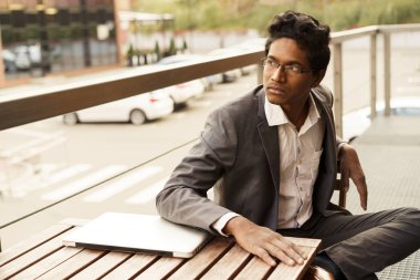 Genç yakışıklı adam masada oturuyor.