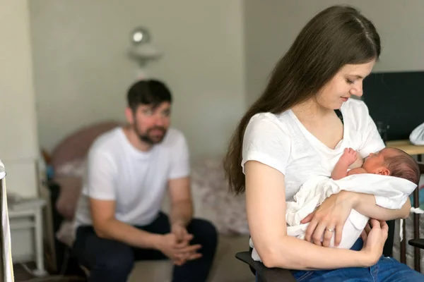 Padre y madre con un hijo recién nacido sentado en la habitación —  Fotos de Stock