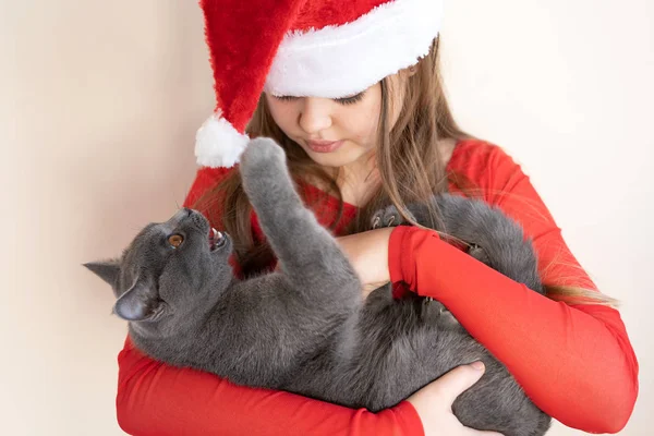 Ein Teenager-Mädchen mit rotem flauschigem Weihnachtsmann-Hut und rotem Pullover — Stockfoto
