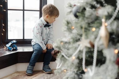 Güzel giyimli bir Noel ağacının yanında oturan küçük çocuğu gücendirdim.