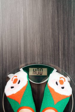 Noel eğlencesinde terazide duran kız. Kırmızı yeşil çoraplı kardan adam.