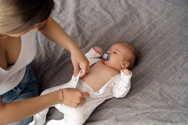 Madre con suo figlio appena nato sdraiato sul letto sotto i raggi del sole — Foto Stock