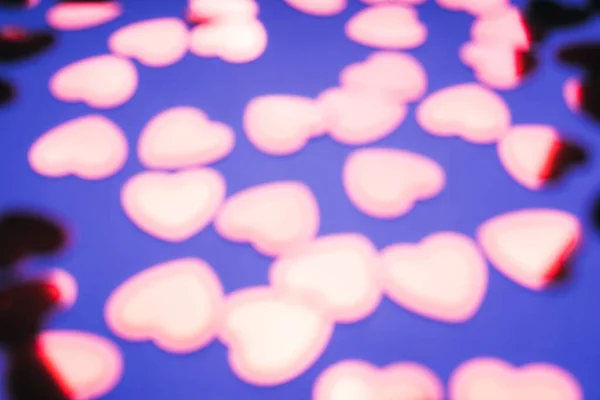 Banner of foil red confetti in shape of hearts on blue neon purple background — Stock Photo, Image