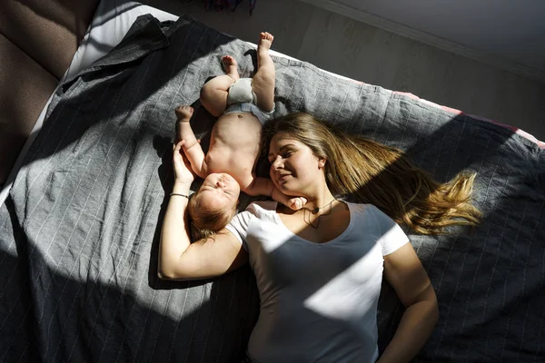 Madre con su hijo recién nacido yacía en la cama —  Fotos de Stock