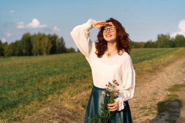 Yüzünde kırmızı kıvırcık saçlı ve çiller ile güzel genç kadın.